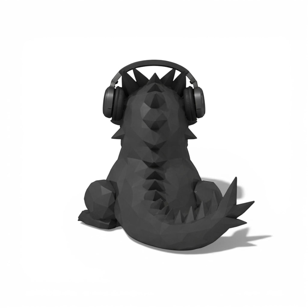Happy3dWorld black geometric dragon headphone stand with a low-poly design holding over-ear gaming headphones.