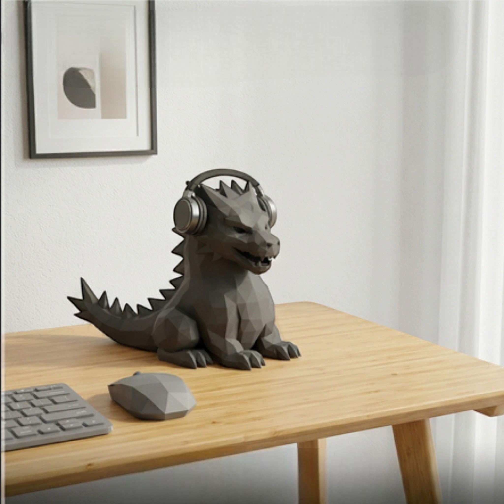 Happy3dWorld geometric dragon headphone stand in matte grey PLA on a wooden desk with a matching low-poly mouse.