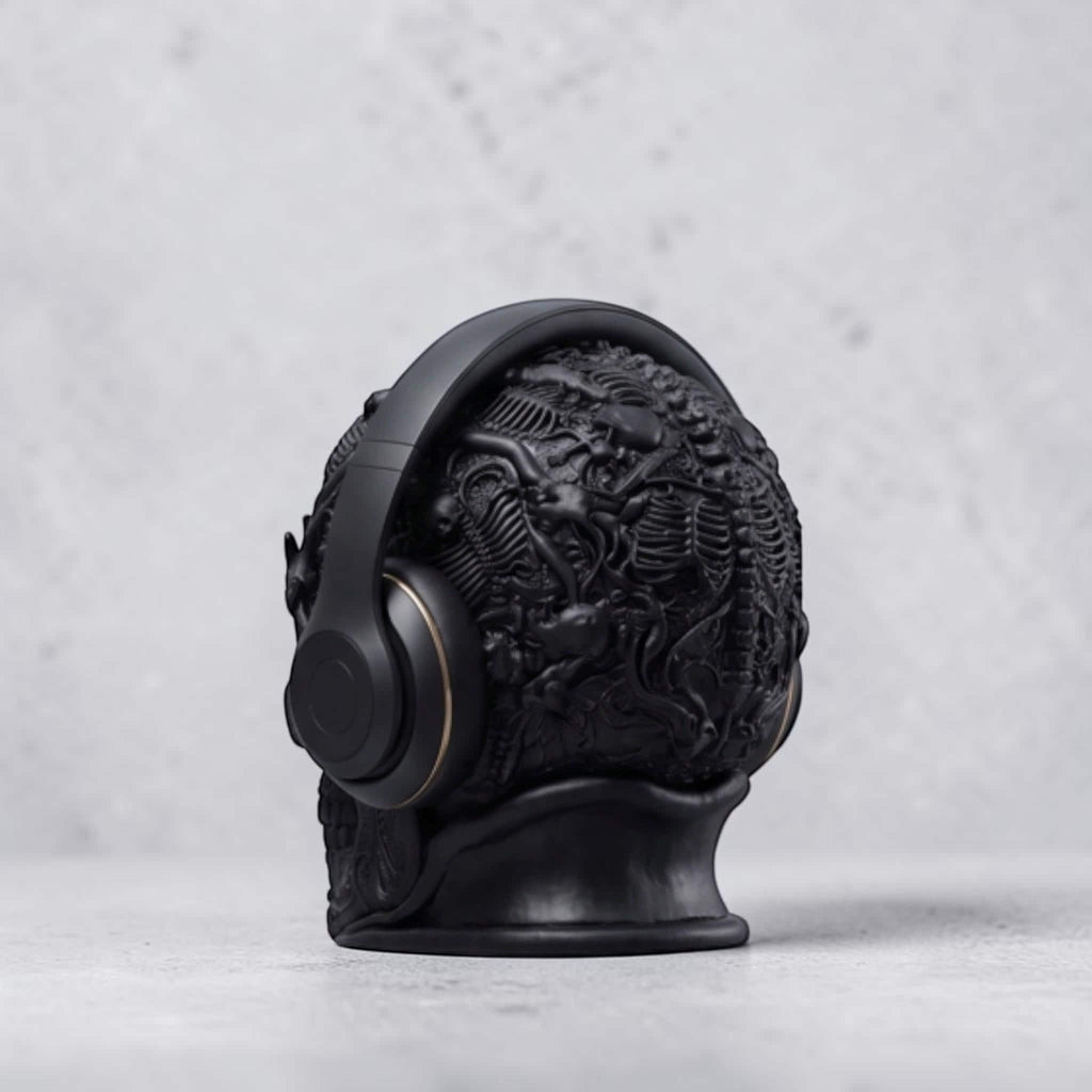 Happy3dWorld matte black gothic skull headphone stand with intricate baroque textures holding over-ear headphones.