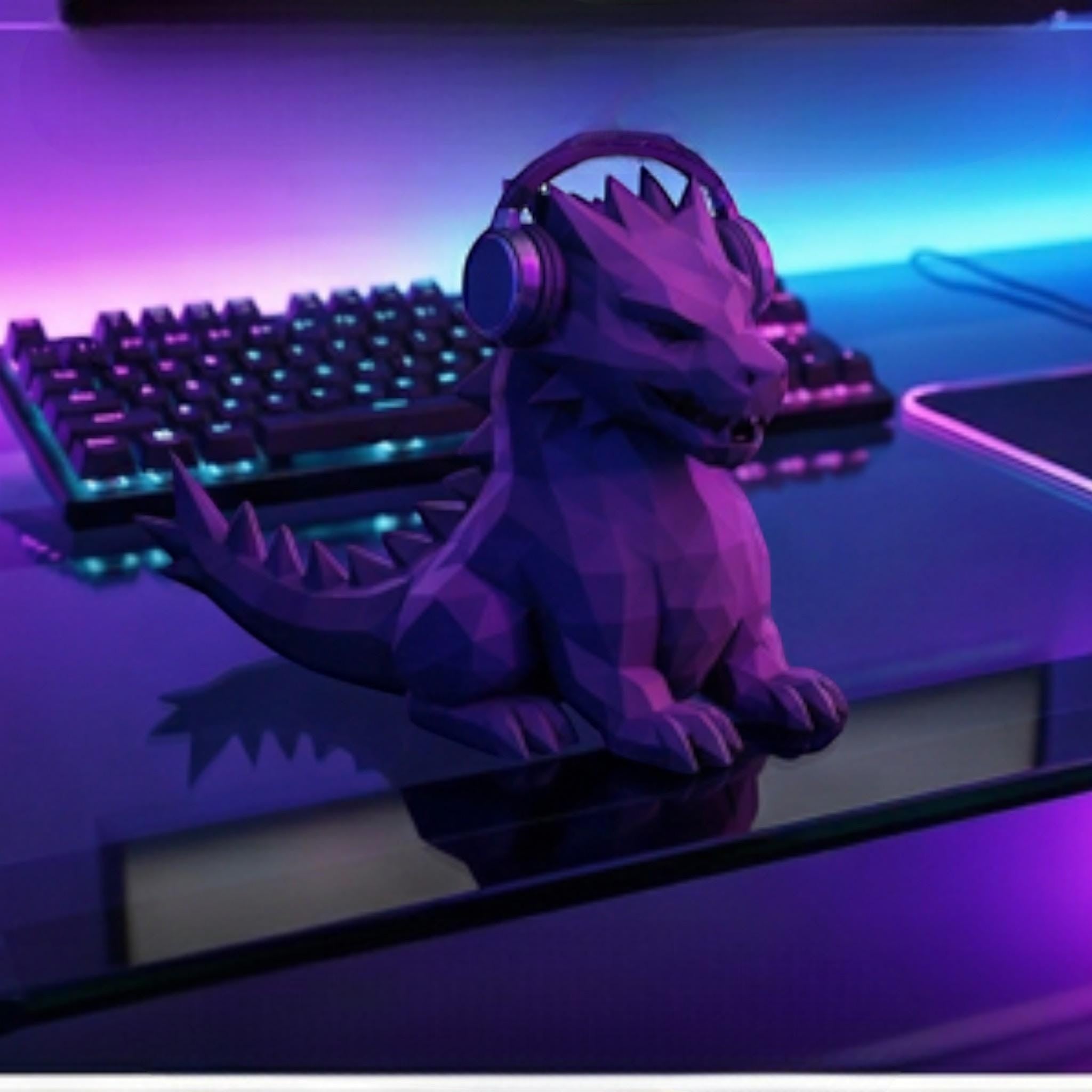 Happy3dWorld purple geometric dragon headphone stand on a gaming desk with RGB lighting and headphones